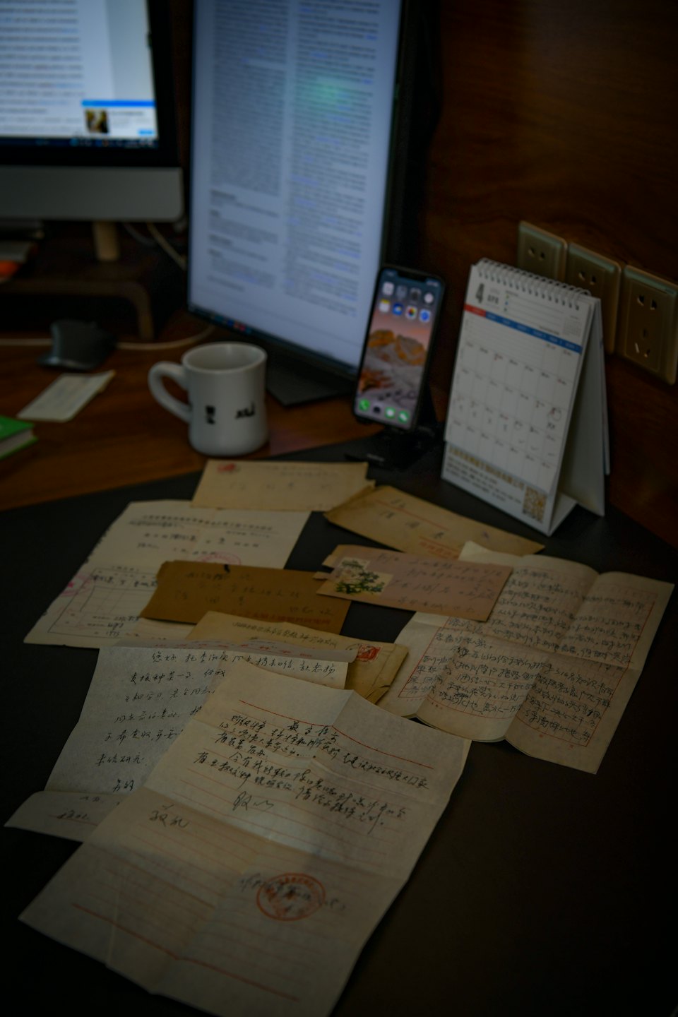 Documentos históricos escritos a mano descansan sobre un escritorio con tecnología moderna.